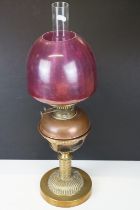 Late 19th / early 20th century brass & copper oil lamp with ruby glass shade and copper font, raised