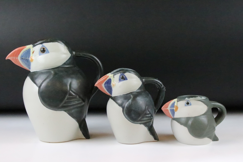 Three graduating John O'Groats pottery puffin jugs. Each moulded into the form of a puffin with hand