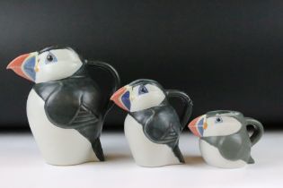 Three graduating John O'Groats pottery puffin jugs. Each moulded into the form of a puffin with hand