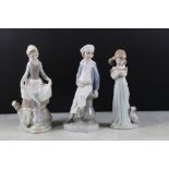 Three Lladro figurines to include a boy holding a model ship, lady with a hare and a girl with a