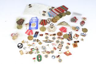 A collection of Russian military medals together with a selection of Russian badges.