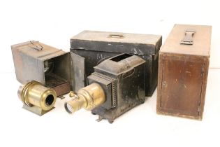 A collection of three magic lantern projectors contained within storage cases. (A/F).