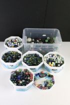 A large collection of mixed glass marbles contained within six boxes.