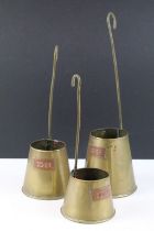 Set of three graduating cider measures with copper labels and hanging handles, largest approx 32cm