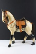 Painted wooden model of a horse with mane, tail and leather saddle, approx 50cm high