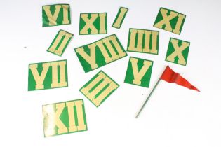 A collection of tin plate Roman numeral markers together with a red tin plate flag.