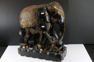 Carved South East Asian hardwood figure group of an elephant and calf, with black painted