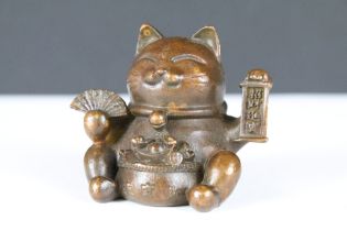 An ornamental Japanese bronze 招き猫 / maneki-neko (waving / beckoning) lucky cat talisman.