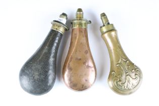 Two antique copper powder flasks with brass fittings together with a leather example.