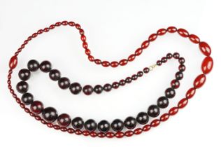 Cherry amber Bakelite graduated bead necklace, sixty four oval beads, the largest measuring approx