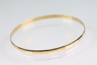 18ct yellow gold bangle, faceted design, width approx 3.5mm, interior diameter approx 20.5cm