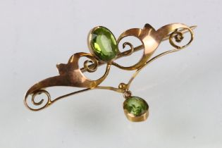 Edwardian peridot 9ct yellow gold brooch, the principal oval mixed cut peridot measuring approx 7.