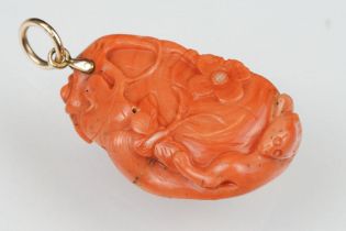 Early 20th century carved coral pendant, the coral depicting long-tailed mammal, butterflies and