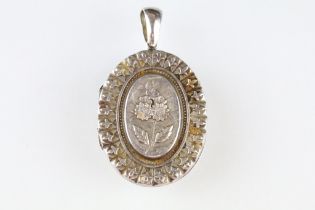 Victorian silver locket pendant, the raised oval centre with cast flower decoration, stylised