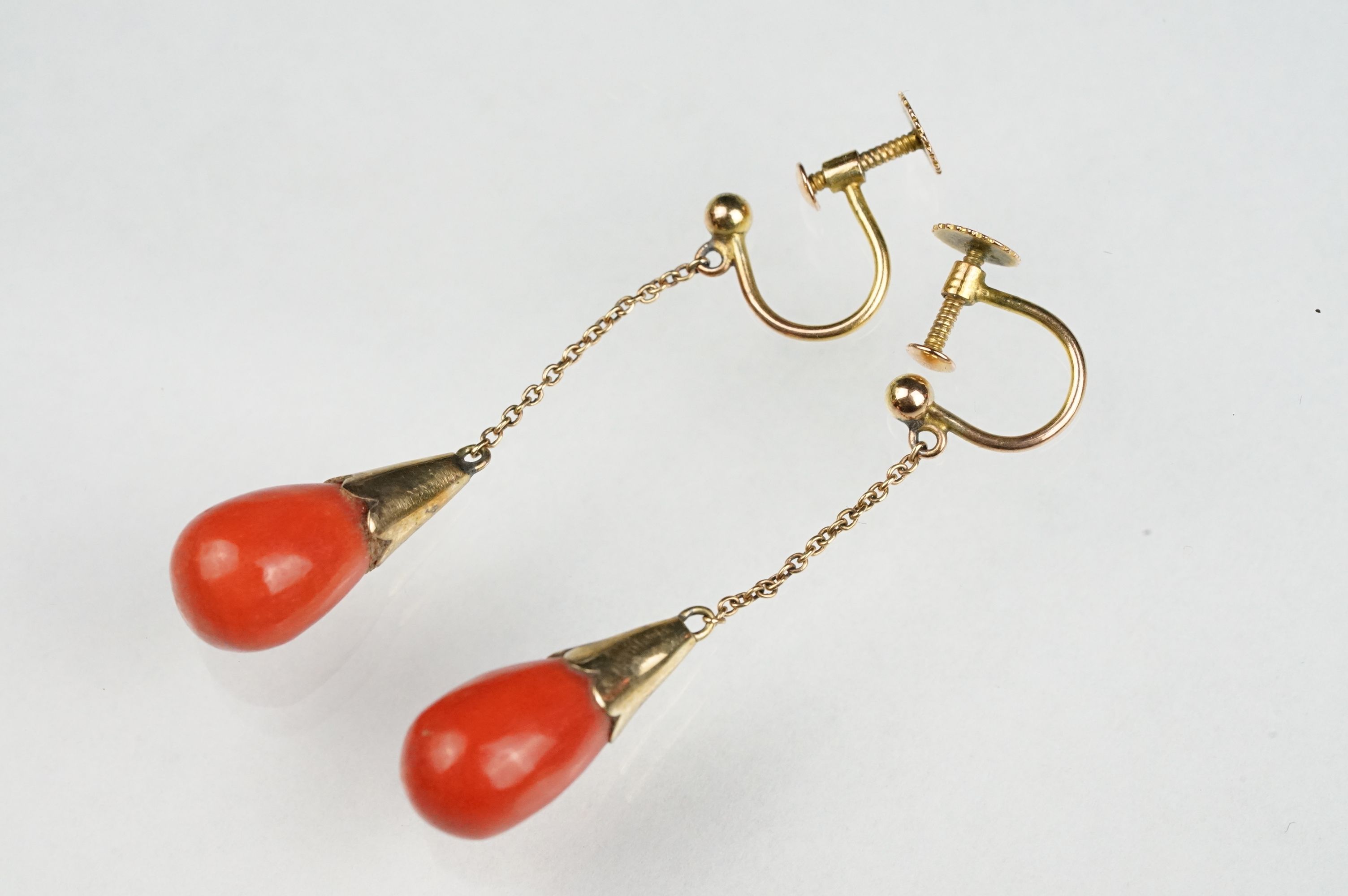 Pair of early 20th century coral 9ct yellow gold drop earrings, the tapered coral with conical