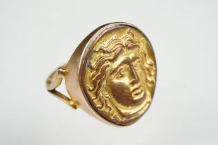 Cameo ring, the gilt metal cast panel depicting a head, rubover yellow metal settings and shank, V