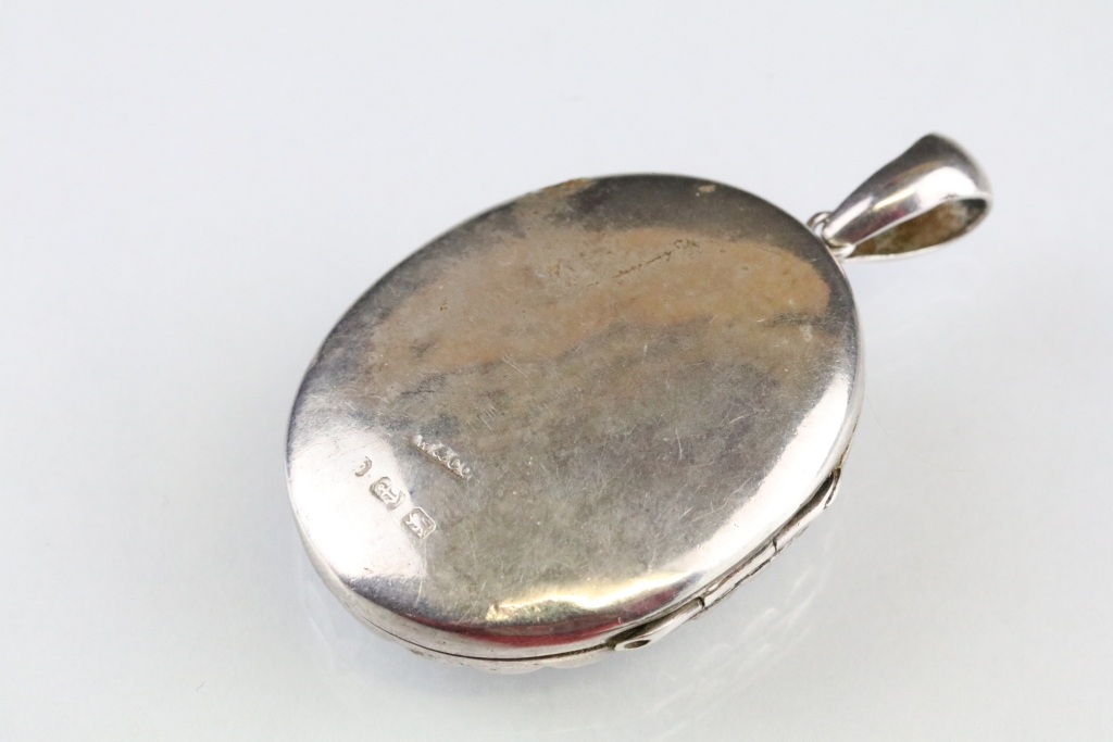 Victorian silver locket pendant, the raised oval centre with cast flower decoration, stylised - Image 2 of 3