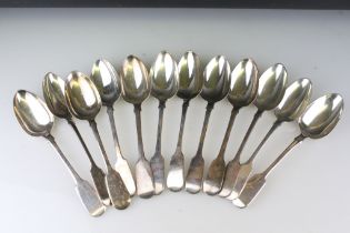 Group of twelve Victorian silver hallmarked fiddle pattern spoons. All British hallmarked, dates