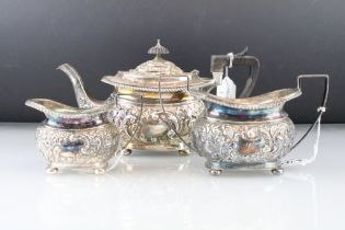 Silver three piece tea service, comprising teapot, milk jug and sugar bowl, each raised on four