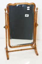 Queen Anne style Walnut Framed Swing Mirror, the shaped mirror with bevelled edges held on a slender