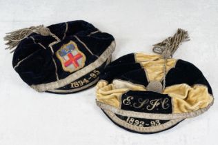 Two late 19th century velvet football caps with tassels and wirework detail, featuring a crested