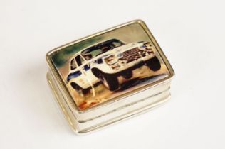 Sterling silver pill box with enamel lid depicting a rally car, approx 3cm wide