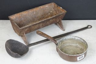 Cast iron trough together with a small copper pan and a cast iron ladle.