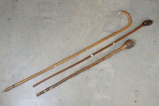 Three vintage wooden walking sticks featuring a knarl-handled examples, bamboo walking stick and a