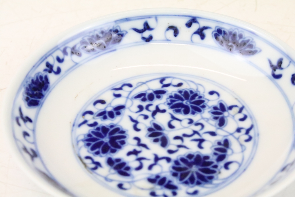 Two 19th Century Chinese blue and white round dishes painted with floral panels and foliate scrolls. - Image 2 of 3