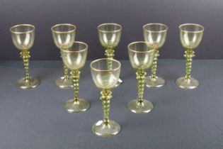 Set of eight green glass Roemer style wine glasses having twist stems and gilt rims. Measures 18cm