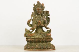 Buddhist copper figure of Guan Yin in a seated pose, with hands clasped, raised on a pedestal
