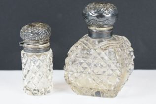 A pair of cut class vanity / scent bottles with fully hallmarked sterling silver lids and collars.