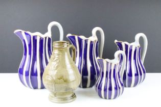 Set of four graduating pottery jugs with gilt, blue & white striped design (tallest approx 22.