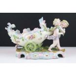 20th Century German porcelain figural vase featuring two putti pulling a floral moulded cart.