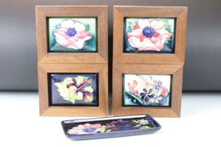 Four Moorcroft ceramic framed mounted ceramic lids to include a hibiscus pattern plaque, two