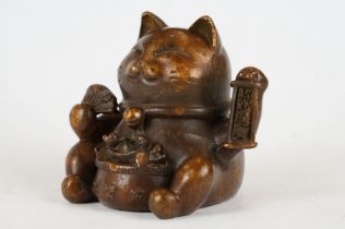 An ornamental Japanese bronze 招き猫 / maneki-neko (waving / beckoning) lucky cat talisman.