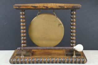 Late 19th / early 20th century carved oak & brass dinner gong, with turned bobbin supports, with