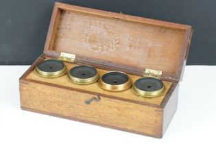 A collection of four optical lenses within brass construction contained within fitted wooden case.