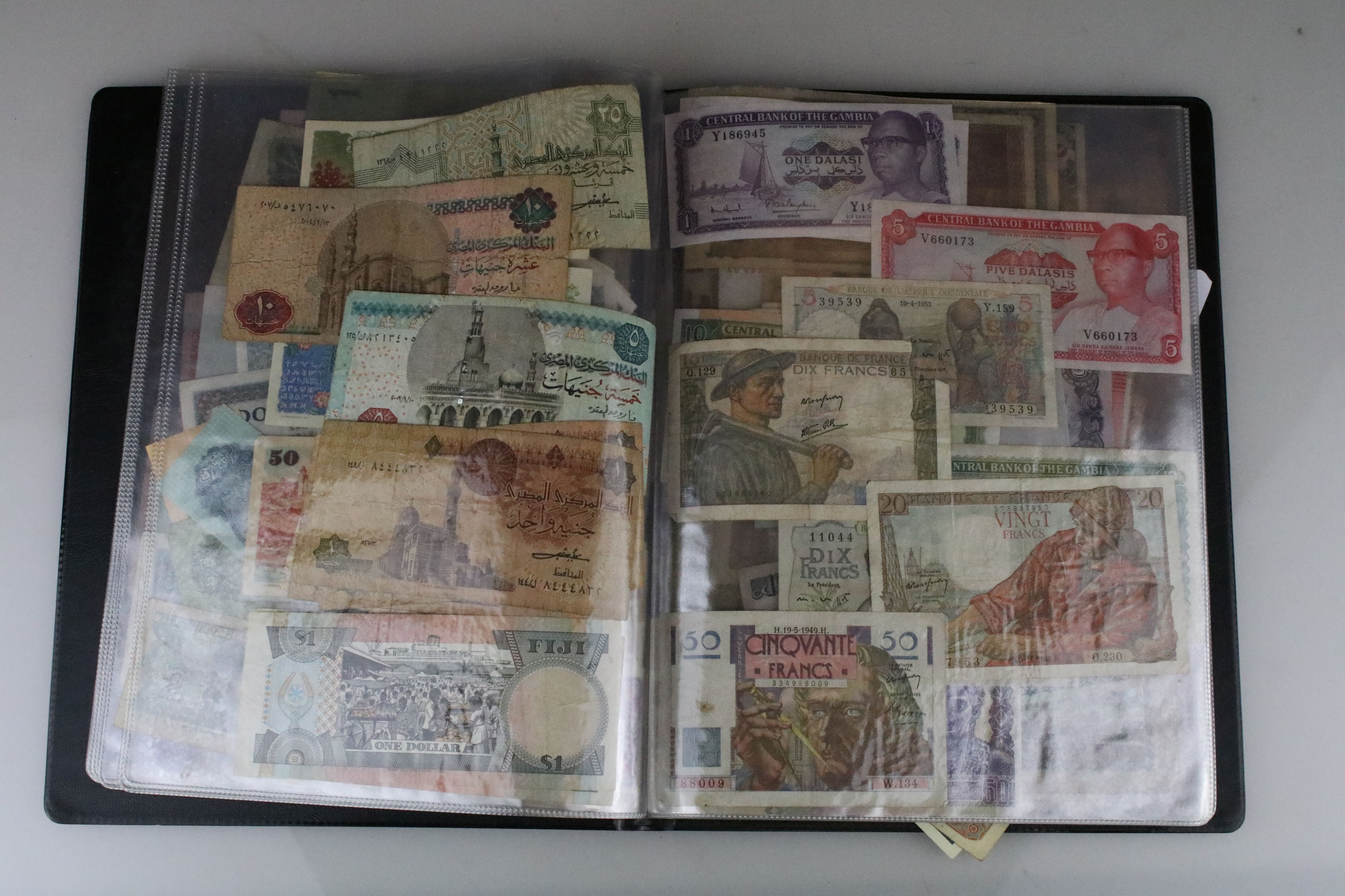 A large collection of World banknotes contained within an album to include France, Germany, Belgium,