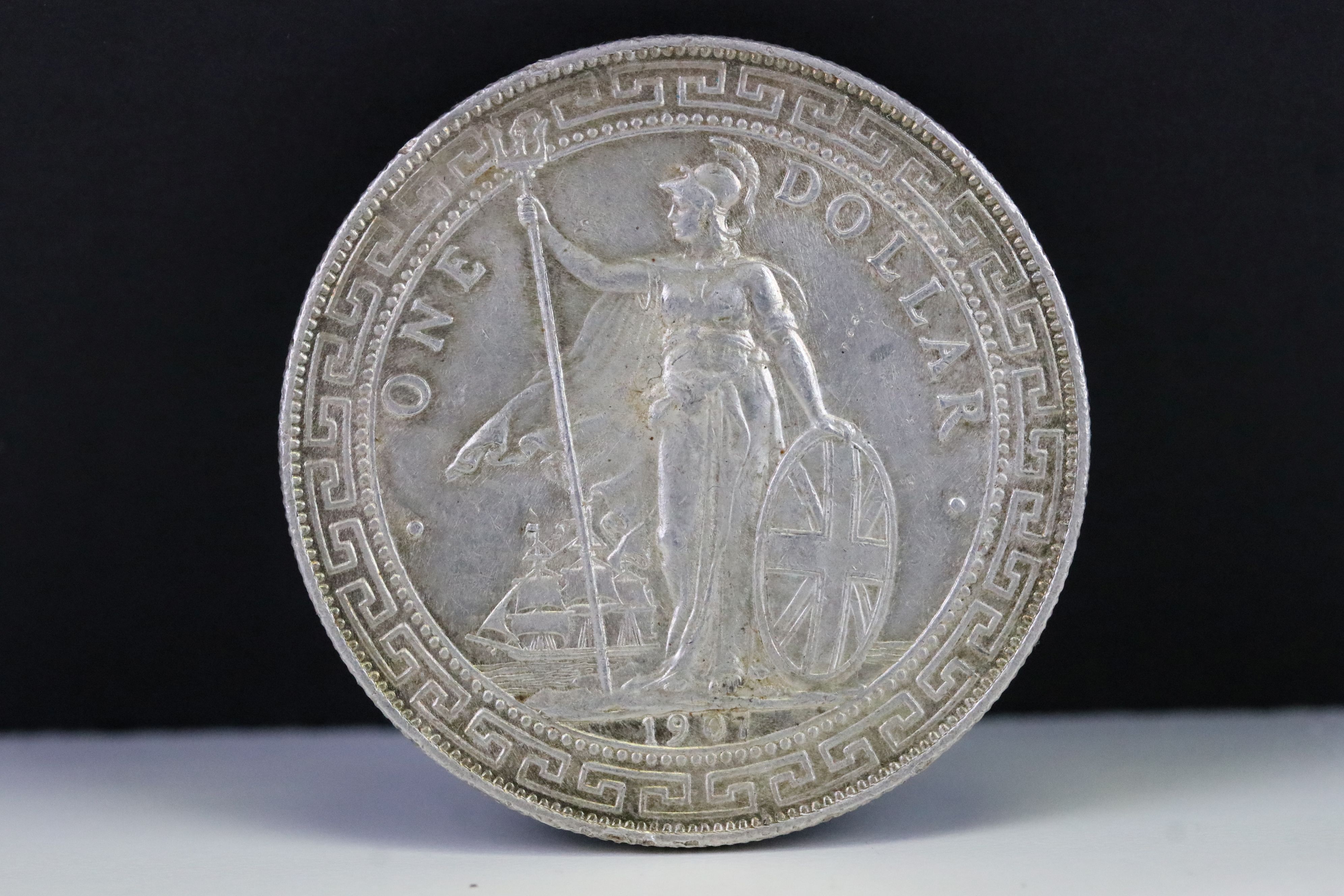 A British 1907 silver One Trade Dollar Coin.