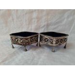 A pair of shaped oval salts with pierced sides, claw and ball feet, 3 1/4" diameter, Sheffield