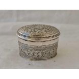 An oval Eastern silver jar and cover with chased decoration, 2" wide,61g