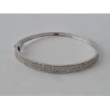 A diamond multi stone set hinged bangle in 9ct white gold 13.5g inc