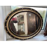 A 19th Century oval Irish mirror with black and gilt frame with faceted glass decoration, 30" wide