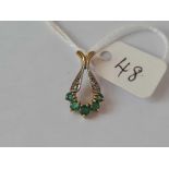 A diamond and green stone pendant in 9ct