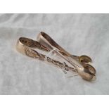 An attractive pair of Victorian sugar tongs decorated with leaves, London 1892 by RS and another