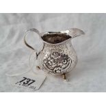 A Victorian squat cream jug embossed with flowers, Birmingham 1857 by GU