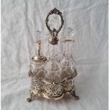 A decorative Victorian six bottle cruet with pierced sides, three claw feet and ring handle, cut