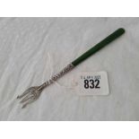 An antique pickle fork with three prongs, stamped STERLG silver with nephite handle