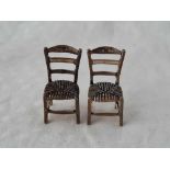 A pair of miniature chairs with rush seats, ladder backs, 1.5" high